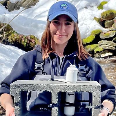 Paige Vichiola holding data logger mounted in cement block