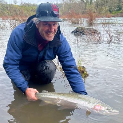 Scott McBain holding fish in river