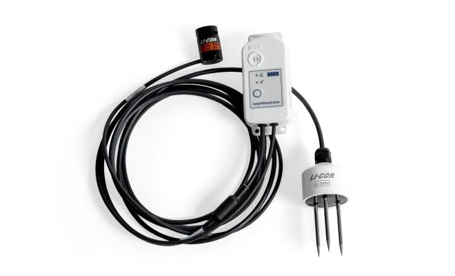 MX2311 studio photo - a small white device connected to 2 senor devices, connected by a long black cable.