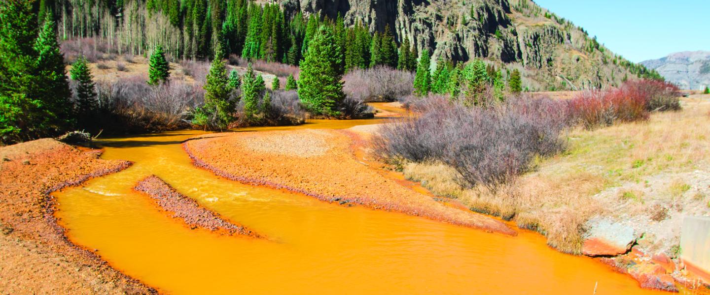 River runs red with mine tailings, severely impacting the aquatic ecosystem.