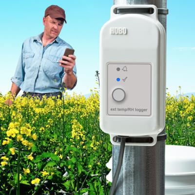Farmer in field downloading data to his phone from the HOBO MX2300