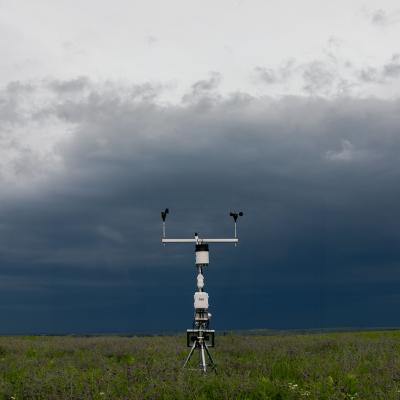 weather station monitors conditions under dark storm clouds in field
