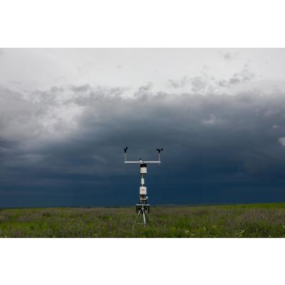 weather station monitors conditions under dark storm clouds in field